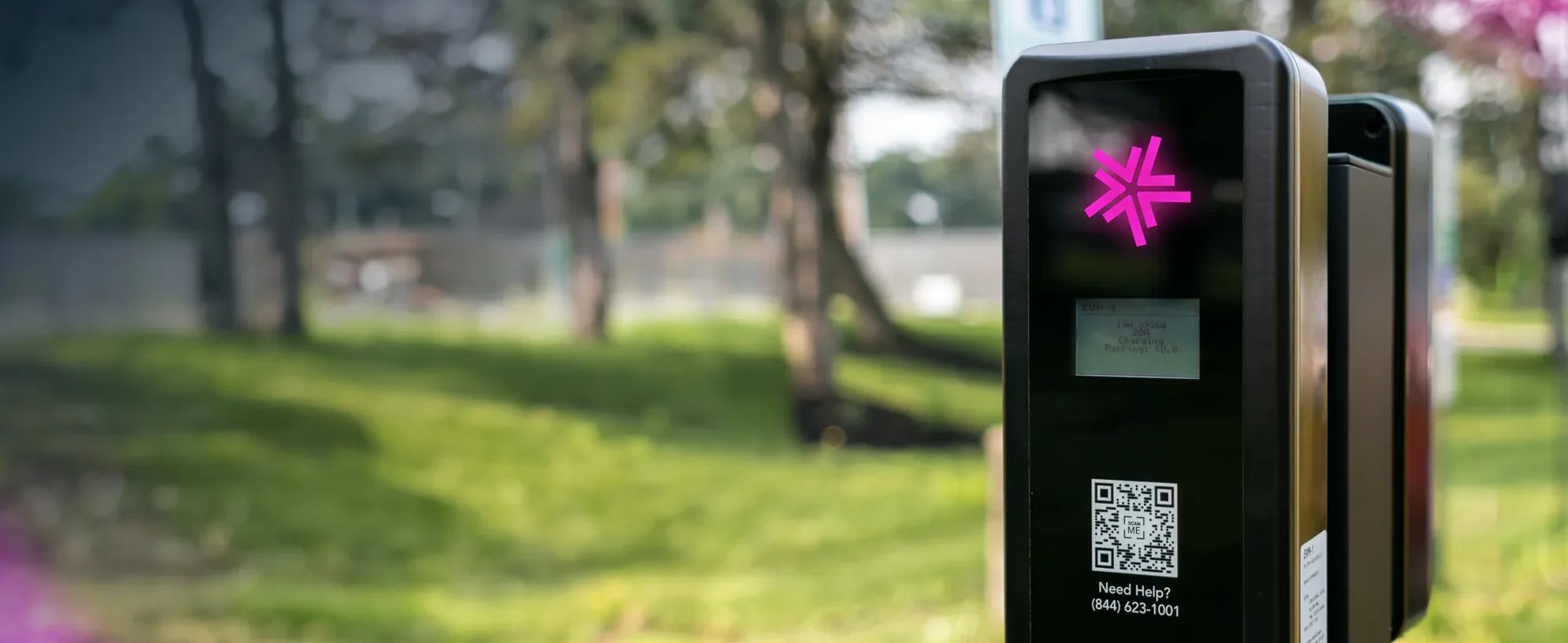 A Lynkwell EV charging station beside a tree-lined park