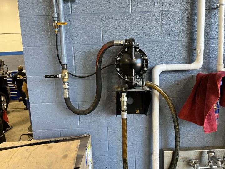Wall-mounted waste oil pump and plumbing